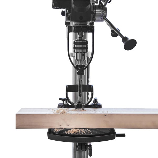 Standbohrmaschine beim Bohren eines Holzstücks