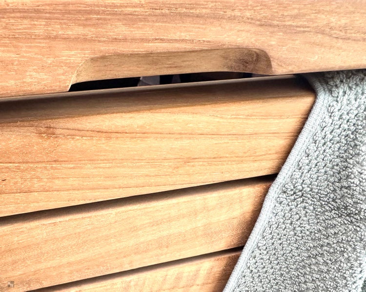 Detailaufnahme eines Holzregals mit Handtuch