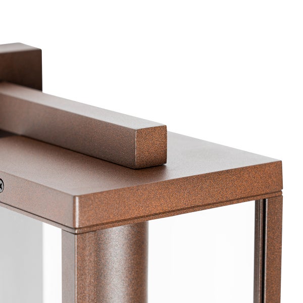 Detailansicht einer rechteckigen Außenwandleuchte in Rostoptik mit strukturierter Oberfläche und Glaseinsätzen.