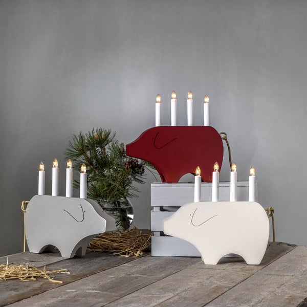 Dekorative Schweine-Lichterbögen aus Holz mit Kerzen auf einem Tisch