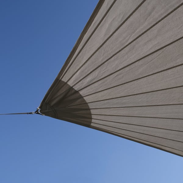 Nahaufnahme eines grauen Sonnensegels aus robustem Gewebe mit verstärkter Ecke und Metallring zur Befestigung.