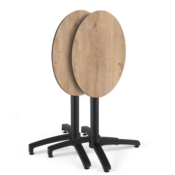 Zwei Bistrotische mit klappbaren runden Tischplatten in heller Holzoptik und schwarzen Metallgestellen.