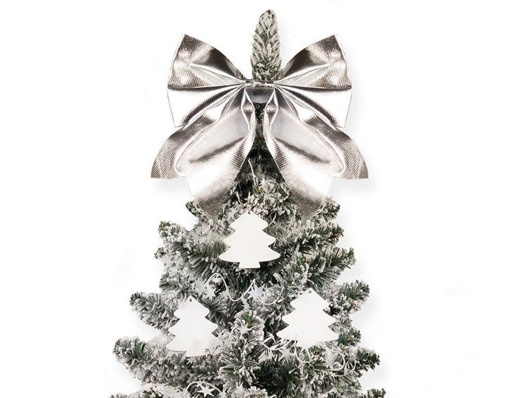 Weihnachtsbaumspitze in Form einer großen Schleife auf einem künstlichen, beschneiten Tannenbaum mit Baumschmuck.