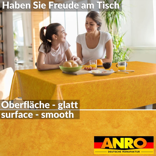 Eine Frau und ein Kind an einem Tisch mit einer glatten, orangefarbenen Tischdecke und ANRO Deutsche Manufaktur Logo.
