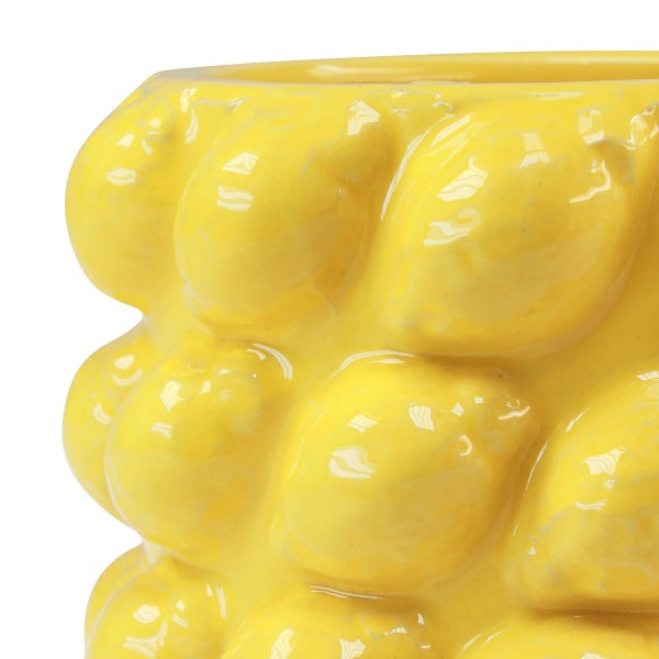 Detail eines gelben, glasierten Keramik-Pflanztopfes mit dreidimensionalem Zitronenmuster.