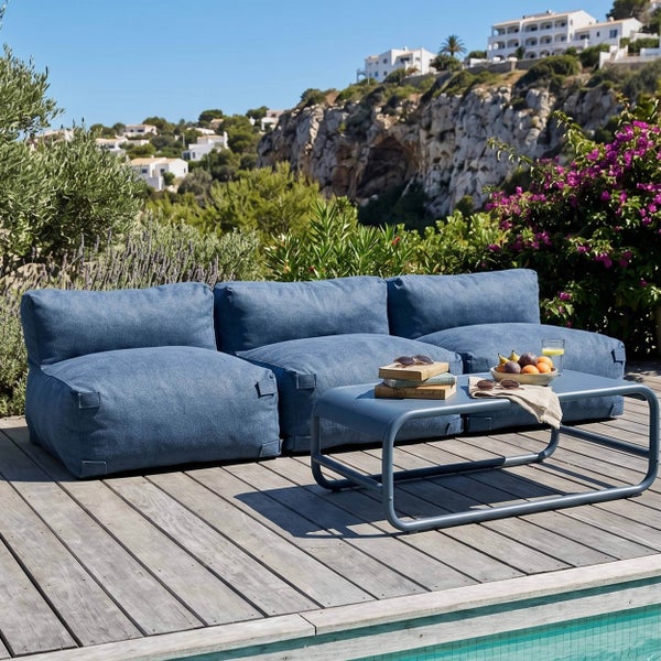 Moderne Garten-Lounge-Möbel aus blauem Stoff auf einer Holzterrasse neben einem Pool mit passendem Metall-Couchtisch.