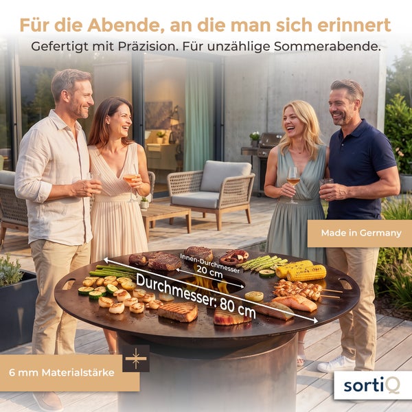 Vier Personen stehen um einen runden Grill mit 80 Zentimeter Durchmesser und 6 Millimeter Materialstärke auf einer Terrasse.