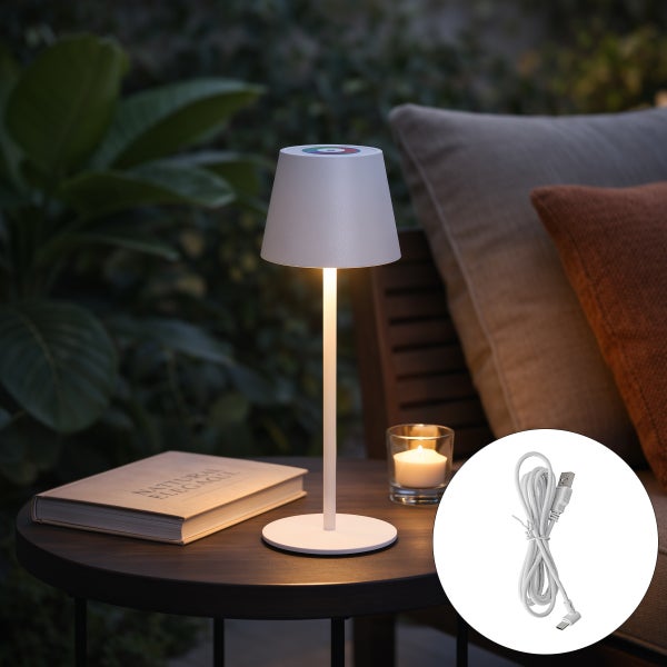 Beleuchtete moderne Akku Tischleuchte für den Außenbereich auf einem Holztisch neben einem Buch und einer Kerze, inklusive USB Ladekabel.