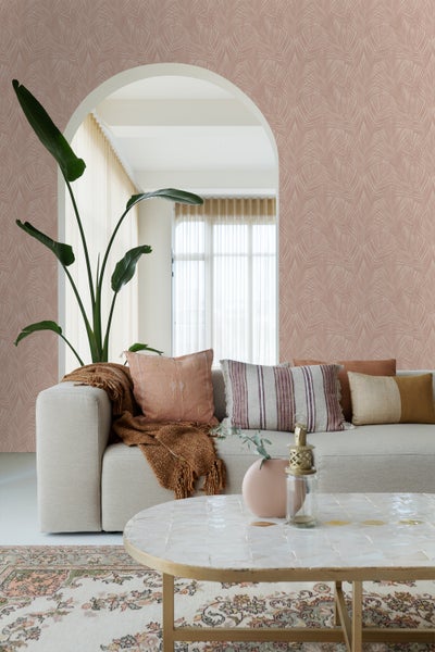 Wohnzimmer mit gemusterter Tapete, Sofa, Kissen und Couchtisch