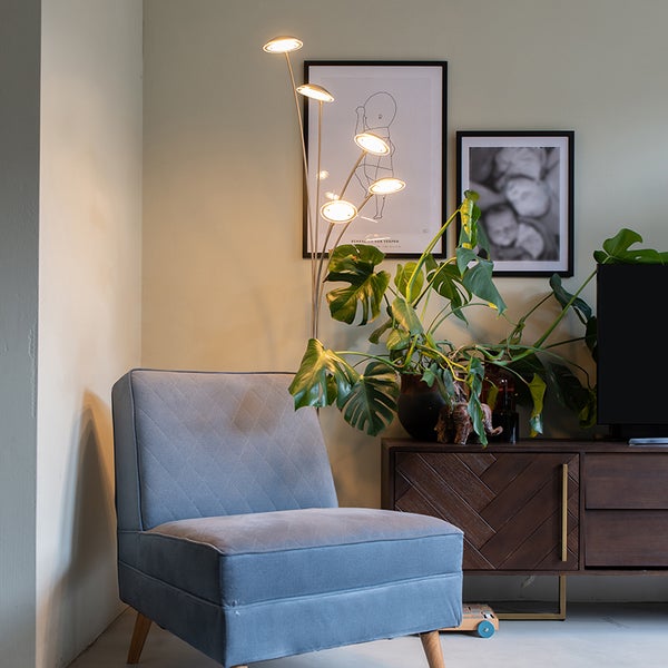 Wohnzimmerszene mit Sessel, Stehlampe und Kommode