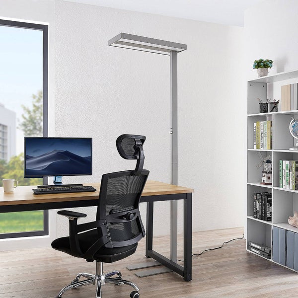 Silberne LED-Stehleuchte in einem modern eingerichteten Büro mit Holzschreibtisch, schwarzem Bürostuhl und weißem Regal.
