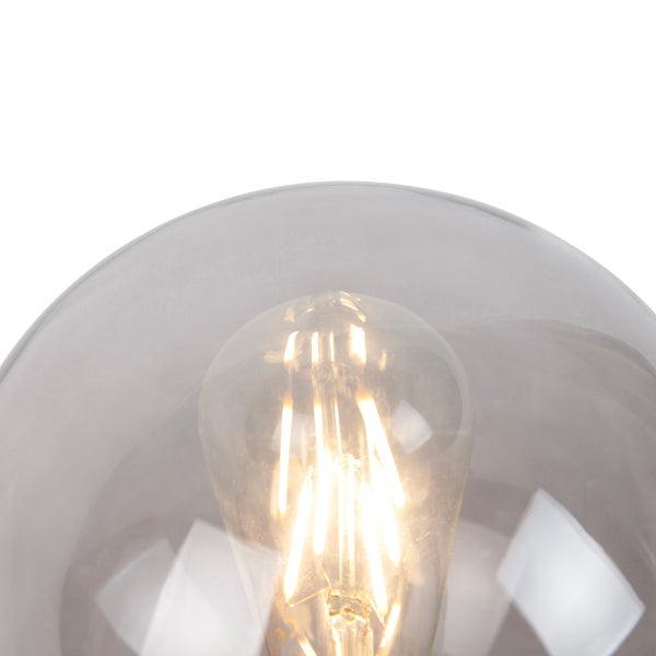 Detailaufnahme einer Lampe mit einer klaren Glaskuppel und einer sichtbaren Glühbirne