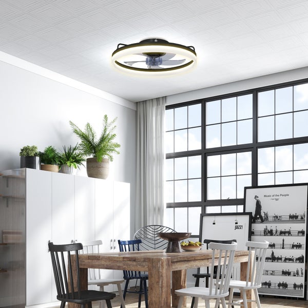 Moderner Deckenventilator mit LED-Lichtring in einem hellen Esszimmer mit Holztisch und großen Fenstern.