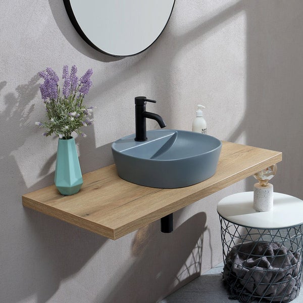 Modernes Badezimmer mit blaugrauem Aufsatzwaschbecken auf einer Holzplatte, schwarzer Armatur, rundem Spiegel und Vase mit Lavendel.
