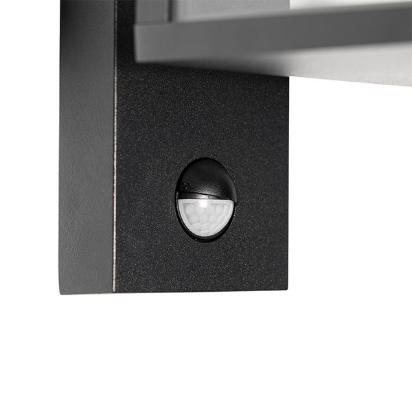 Nahaufnahme eines integrierten Bewegungsmelders an einer schwarzen Außenwandleuchte aus Metall.