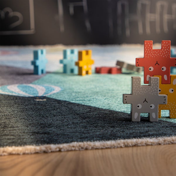 Spielteppich fuer Kinder mit Motiv und Holzspielfiguren in Tierform als Stapelspielzeug.