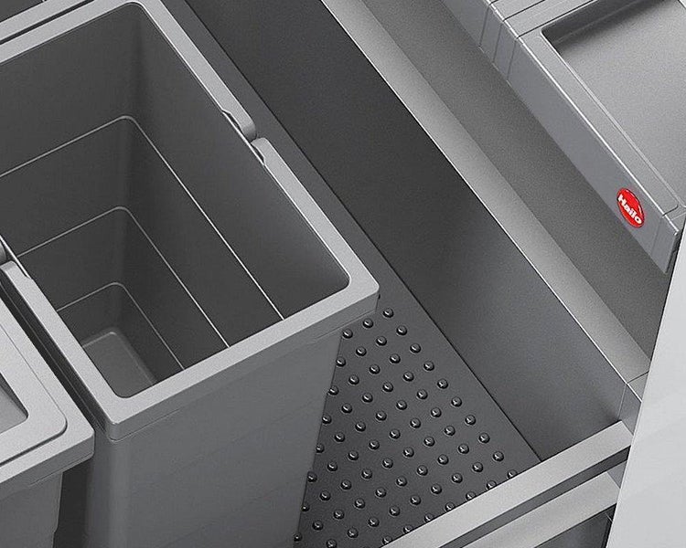 Abfalltrennsystem von Hailo in einer Küchenschublade mit grauen Kunststoffbehältern und einer Noppenmatte. Hailo Logo.