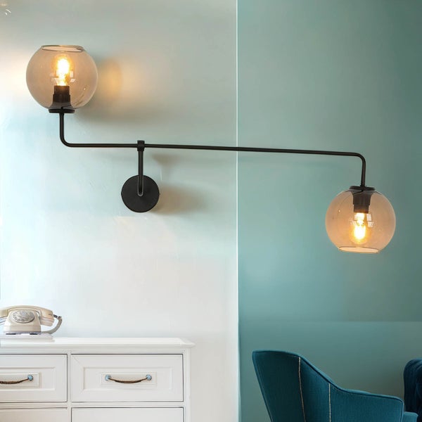 Wandleuchte mit zwei runden Glaskolben und Leuchtmitteln an einem schwarzen Metallarm.