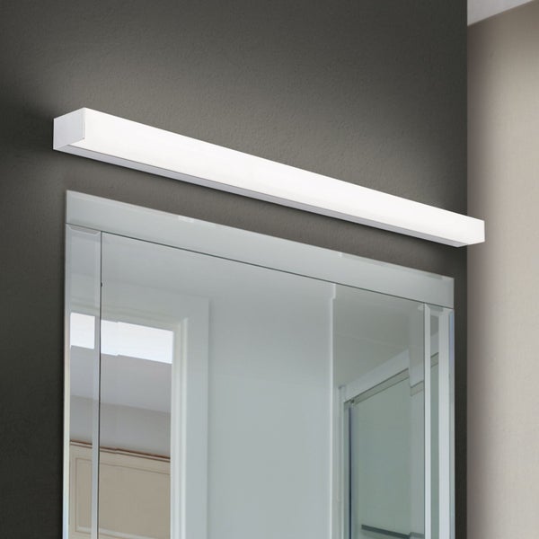 Moderne LED Spiegelleuchte in länglicher Form montiert über einem Badspiegel an einer Wand.