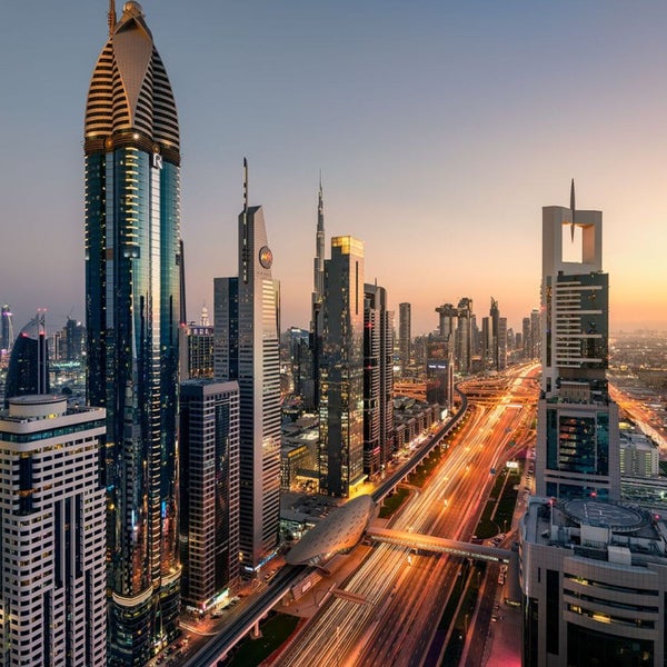 Skyline von Dubai mit Wolkenkratzern und belebter Autobahn im Abendlicht