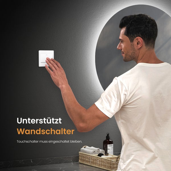Ein Mann bedient einen Lichtschalter im Badezimmer mit Spiegel