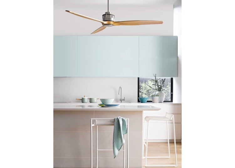 Moderne Küche mit einer Kochinsel, Barhockern und einem Deckenventilator mit Holzflügeln in einem hellen und offenen Raum.