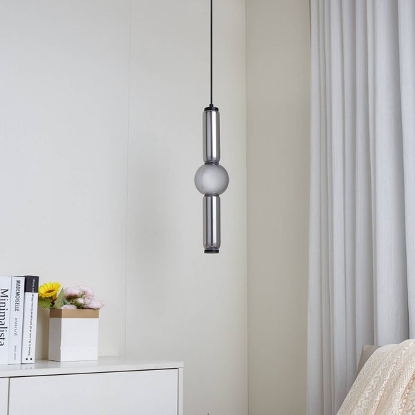 Moderne Pendelleuchte aus Rauchglas mit Zylindern und einer Kugel, hängend in einem hellen, minimalistisch eingerichteten Raum.