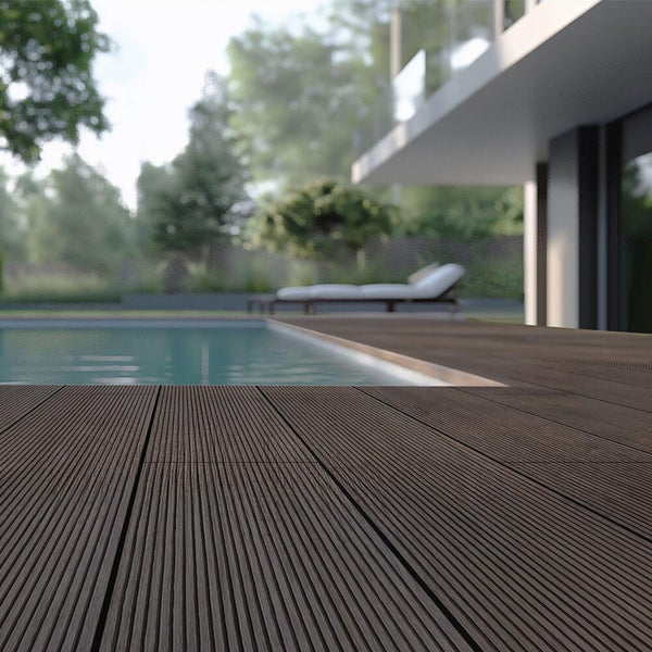 Dunkelbraune WPC-Terrassendielen mit gerilltem Profil an einem Swimmingpool in einem modernen Garten.