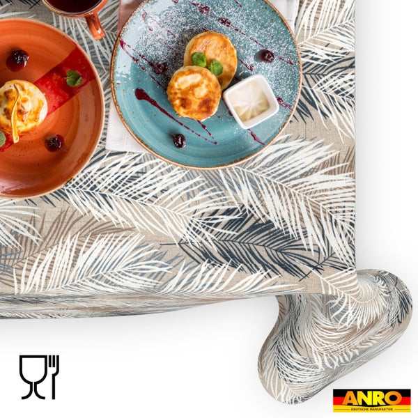 Tischdecke mit Palmenblatt-Muster, darauf angerichtetes Geschirr mit Speisen in einer hellen Atmosphäre, ANRO Logo und Symbol für Lebensmittelechtheit.