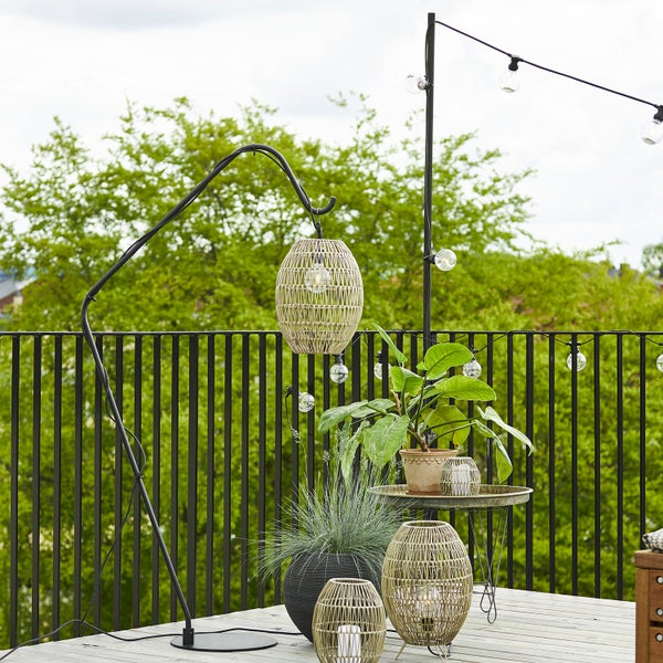 Dekorative Terrassenszene mit Bogenleuchte, Lichterkette und Pflanzen