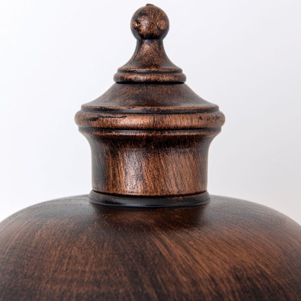 Detailaufnahme der dekorativen Metallspitze einer Leuchte in bronzefarbener Antik-Optik.