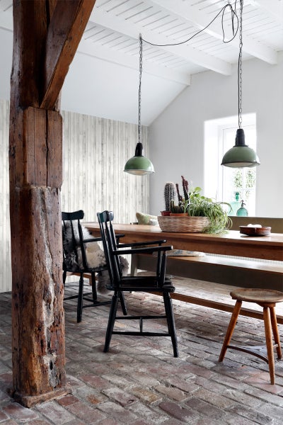 Esszimmer mit Holztisch, Stühlen, Hängelampen und Holzsäule