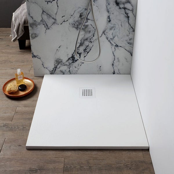 Flache weiße Duschwanne mit zentralem Ablauf in einem modernen Badezimmer mit Wand in Marmoroptik und Boden in Holzoptik.