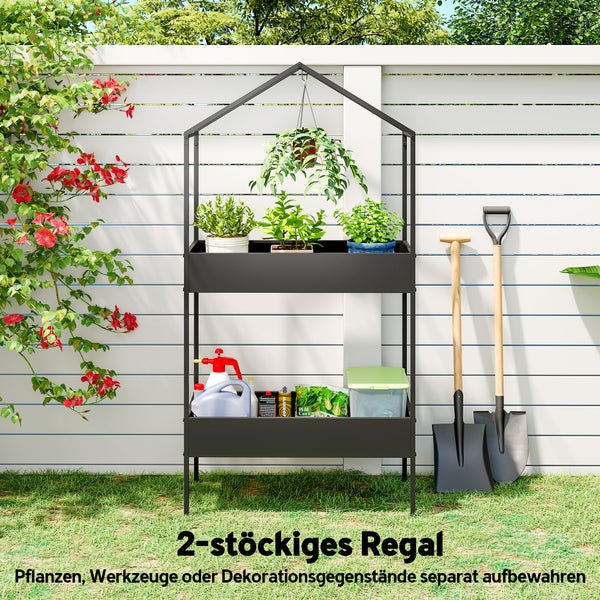 Zweistöckiges Gartenregal in Hausform aus Metall, bestückt mit Pflanzen und Gartenwerkzeugen vor einem Zaun.