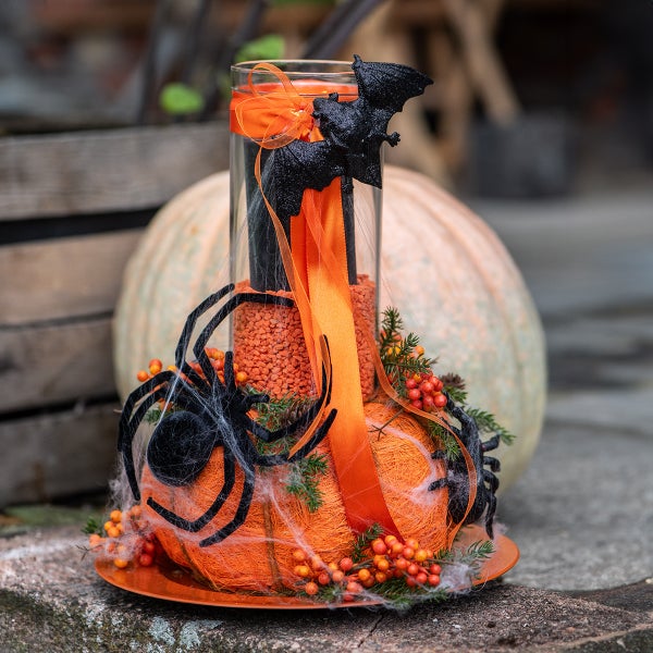 Halloween-Dekoration mit Kürbis, Spinnen, Fledermäusen und Kerze