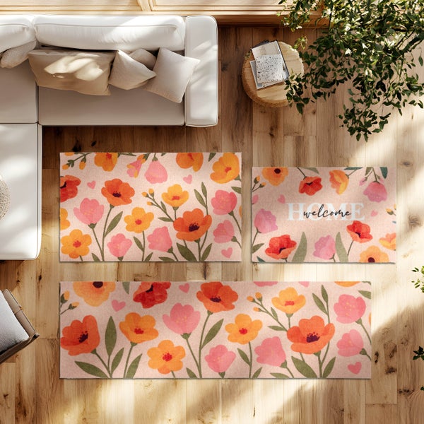 Florale Fußmatten und Läufer mit orangefarbenem und rosa Mohnblumenmuster auf Holzboden in einem hellen Wohnzimmer.
