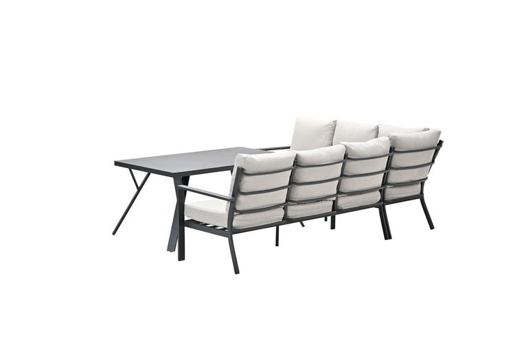 Garten-Lounge-Set bestehend aus einem dunklen Metalltisch und einem Ecksofa mit hellen Polsterkissen.