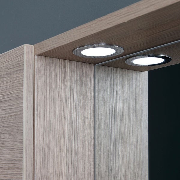 Detailaufnahme von zwei eingebauten LED-Leuchten in einem Möbelstück mit Holzstruktur