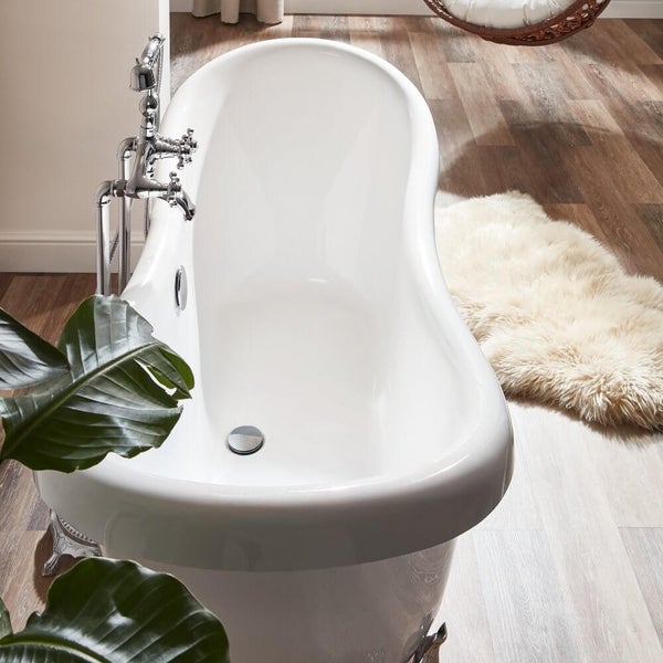 Freistehende Badewanne in nostalgischem Design mit Standarmatur in einem Badezimmer mit Holzoptik Boden und Kunstfellvorleger.