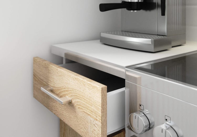 Detailansicht einer Küche mit Schublade, Herd und Kaffeemaschine.