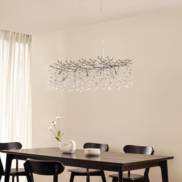 Hängelampe im Wohnzimmer mit Kristallanhängern und Metallgestell in Astform.