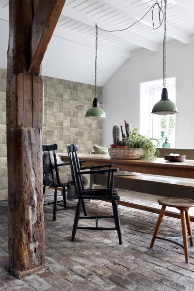 Heller Speiseraum mit Holztisch, Stühlen, Leuchten und gemusterter Tapete.