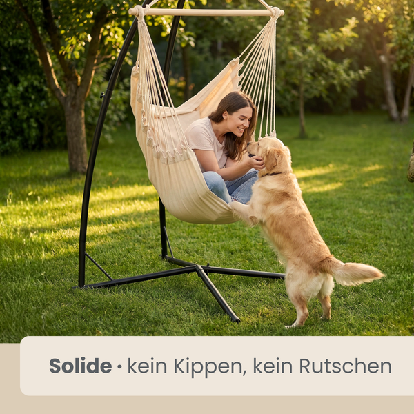 Stoff-Hängesessel mit schwarzem Metallgestell im hellen Garten. Eine Frau sitzt im Sessel und streichelt einen Hund. Stabil und rutschfest.