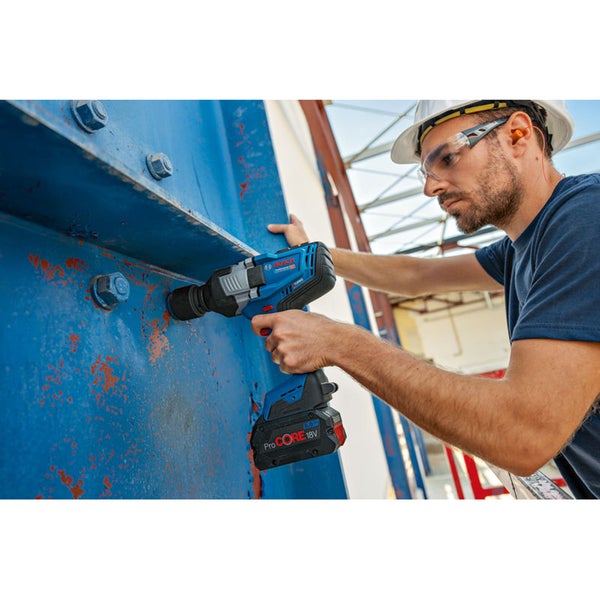 Ein Mann mit Schutzhelm und Schutzbrille bedient einen Akku-Drehschlagschrauber an einer Stahlkonstruktion.