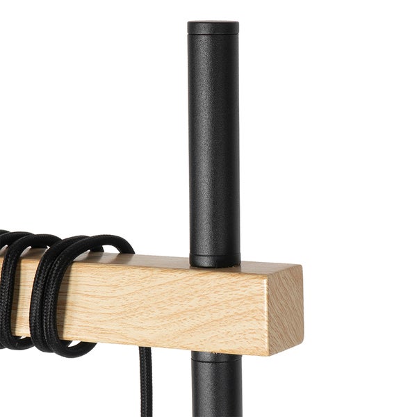 Detailansicht einer Stehlampe mit Holzbalken und schwarzem Kabel