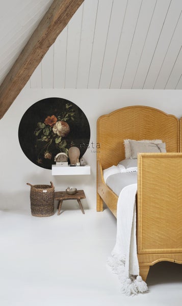 Heller Raum mit einem Bett aus hellem Holz, einem runden Wandbild mit Blumenmuster und einer kleinen Dekorationsecke.