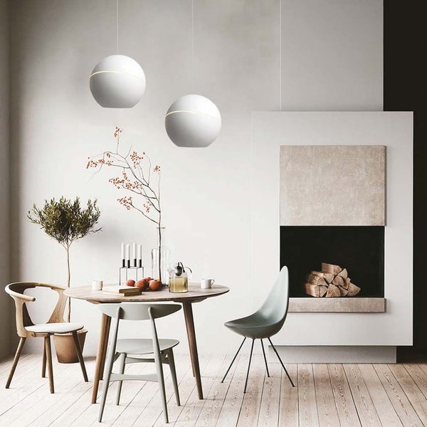 Esszimmer mit Esstisch, Stühlen, kugelförmigen Pendelleuchten und Kamin.
