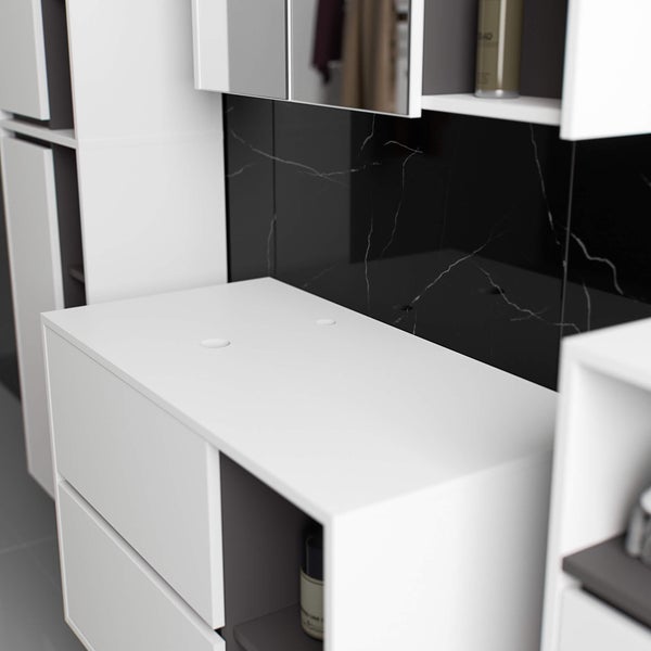 Detailaufnahme eines Badezimmers mit weißem Waschtischunterschrank und schwarzer Marmorwand