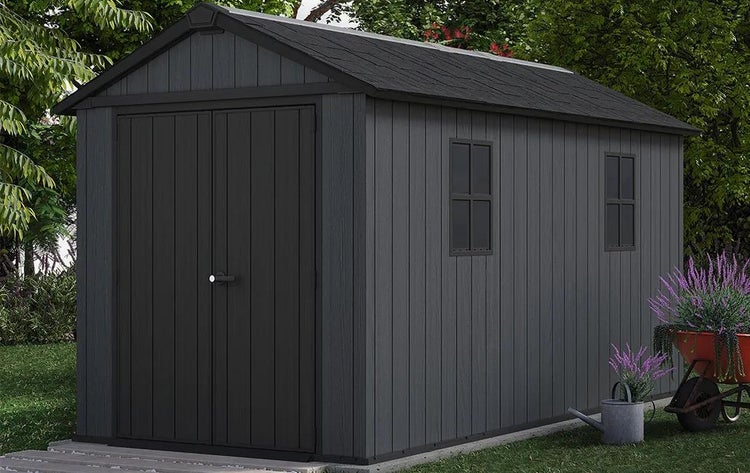 Großes Gartenhaus in Anthrazit mit Satteldach, Doppeltür und Seitenfenstern in einem Garten.