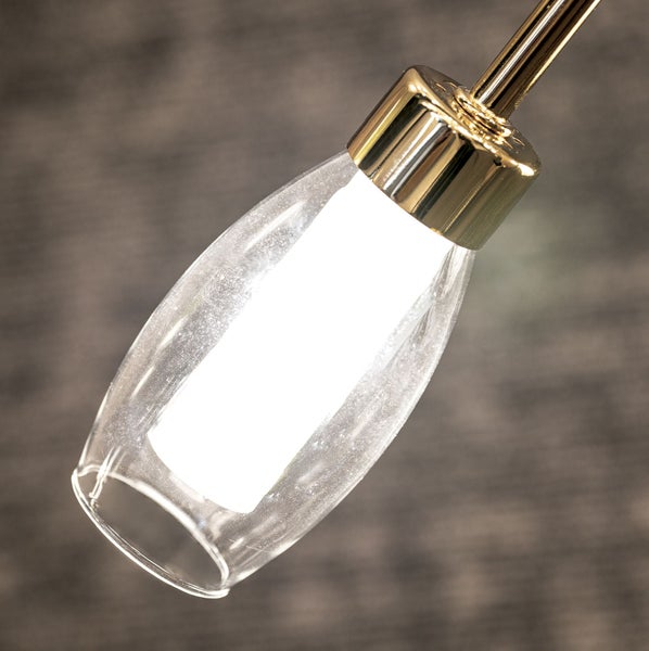 Moderne Leuchte mit goldfarbener Fassung und einem länglichen Glasschirm aus klarem Glas mit integriertem Leuchtmittel.